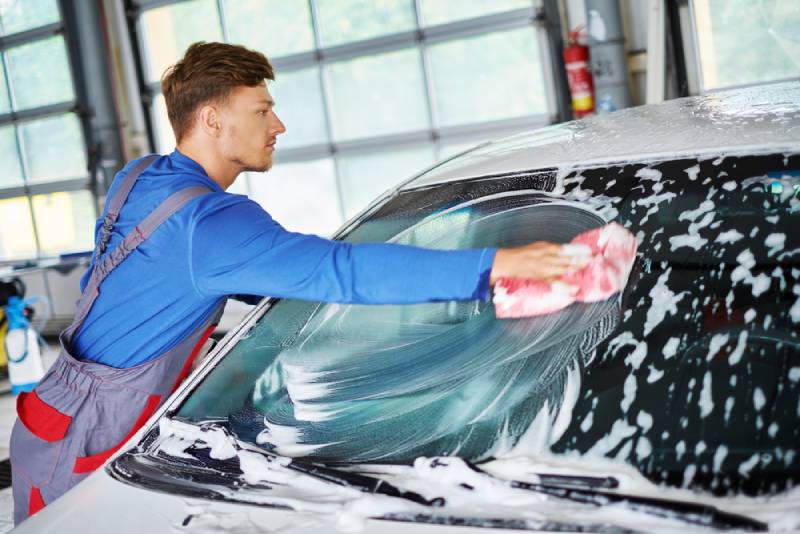 employé de station lavage nettoyant voiture à la main - optimiser la rentabilité d'une station de lavage auto