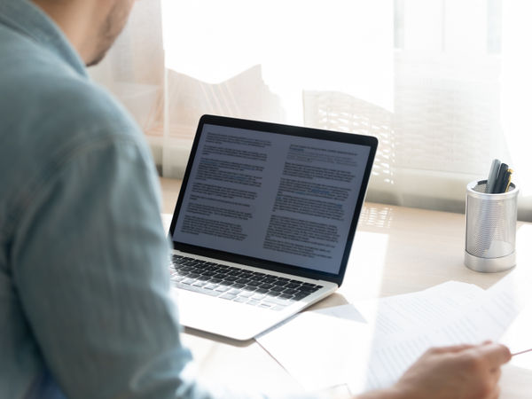 entrepreneur writing a long business plan online on his laptop